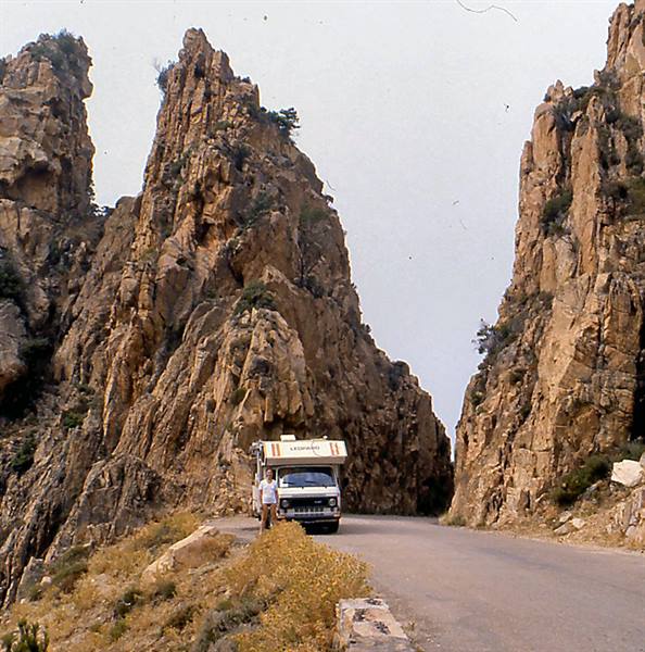 Motorhome parked on the road among the red rocks of Calanques de Piana