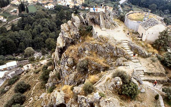 Tourists climb the stone staircase on the rocky ridge above the village