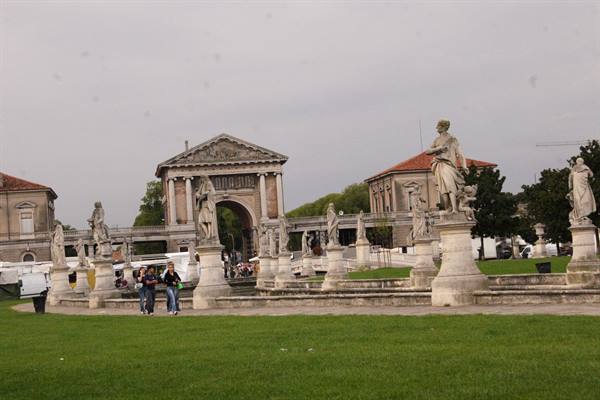 Prato della Valle in Padua: stone statues on the island, tourists walking on the lawn