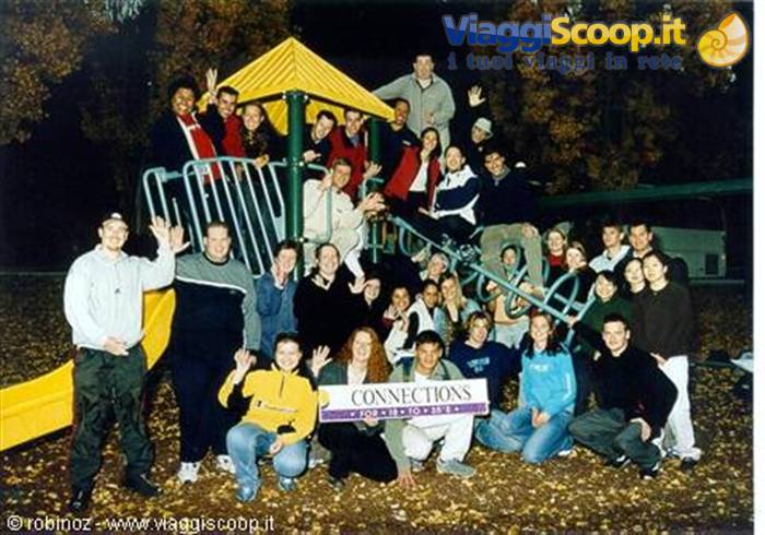 Group of young people with Connections banner on playground equipment, night flash