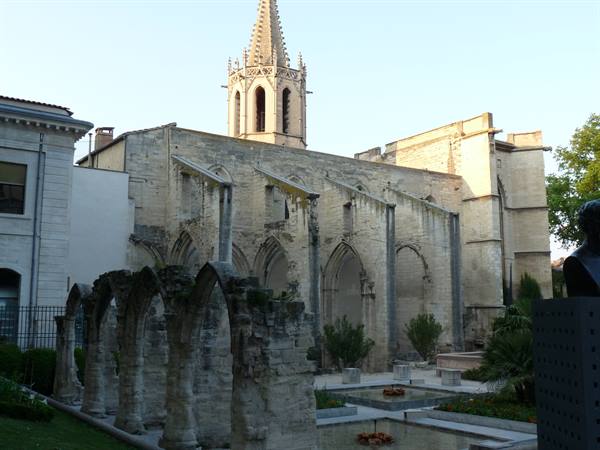 gothic stone ruins with pointed arches, sharp bell tower, warm morning light