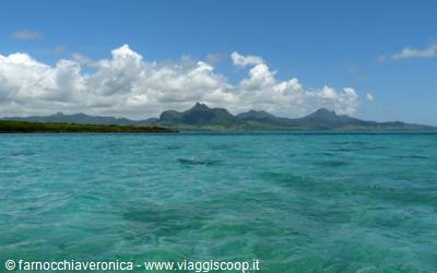 Turquoise lagoon with cloudy volcanic mountains in the background, Mauritius