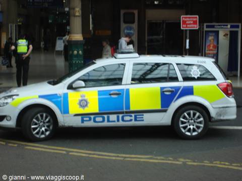 Yellow and blue British police car parked outside Victoria Station