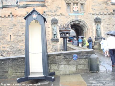 Wooden sentry box before Edinburgh Castle gate, tourists with umbrellas in the rain