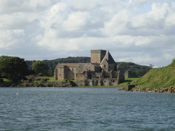 Inchcolm Abbey's stone ruins rise on a green island amid the waters