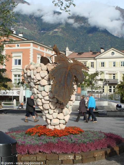 Stone grape sculpture with iron leaf in Merano town square
