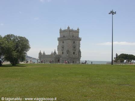 Visitors stroll on the lawn in front of Belém Tower, Lisbon