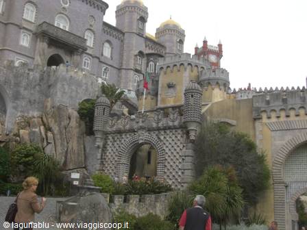 Tourists beneath the Pena Palace in Sintra, decorated arches and battlements