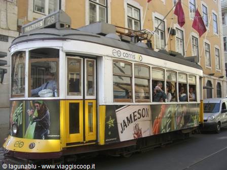 Yellow Carris tram number 28 packed with passengers in Lisbon