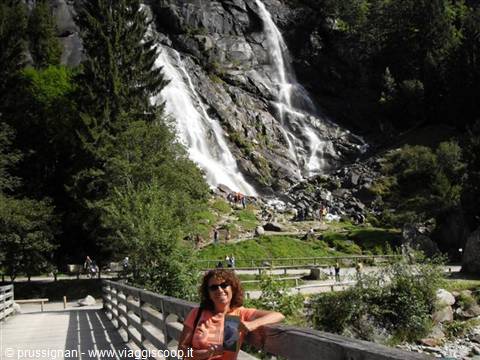 Woman leaning on a wooden fence in front of Nardis waterfalls