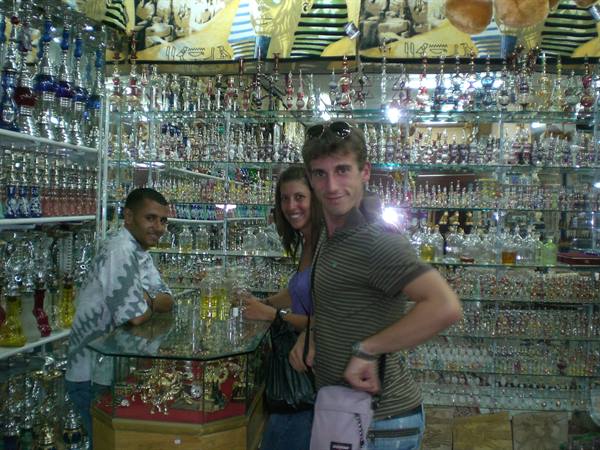 Smiling tourists in a shop full of shisha pipes and glass bottles