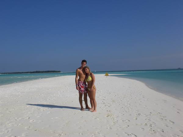 Couple in swimwear on a white sandbank between turquoise waters