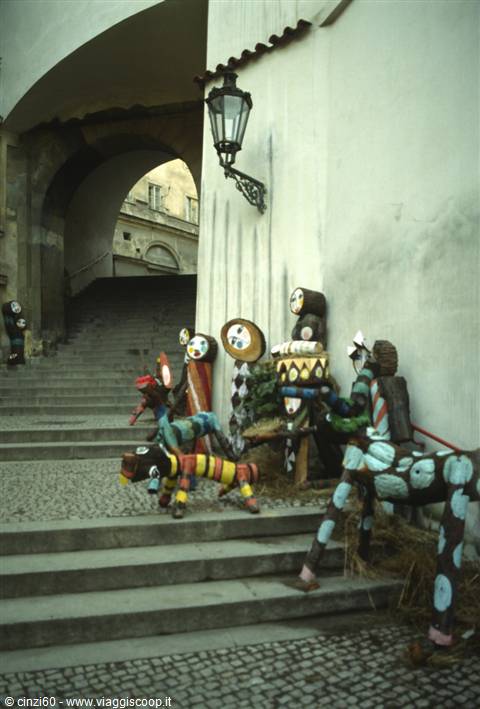 Stone staircase with lantern and colorful painted wooden sculptures by the wall
