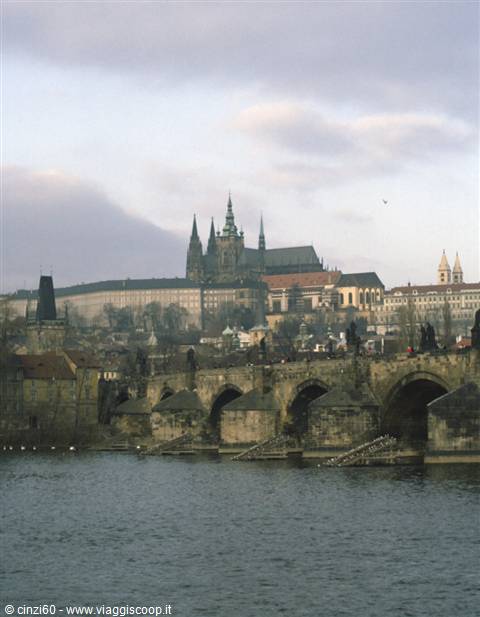 Charles Bridge stone arches over the Vltava with Prague Castle and St Vitus Cathedral