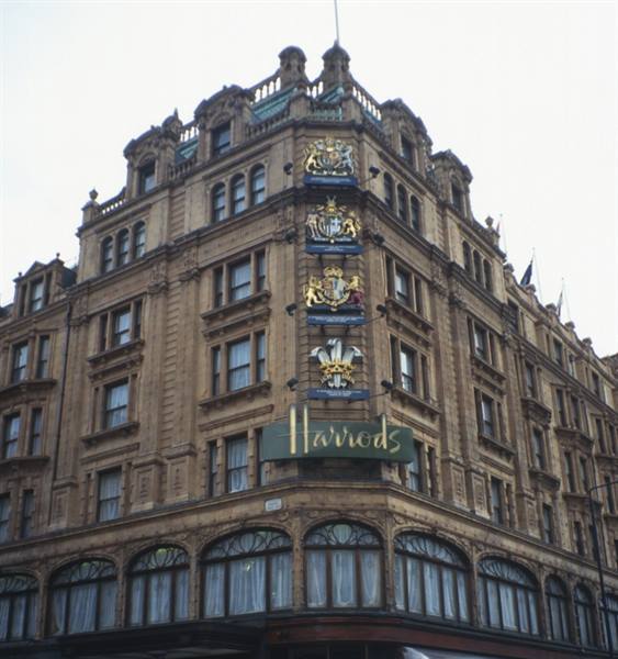Terracotta facade of Harrods department store, London, with green sign