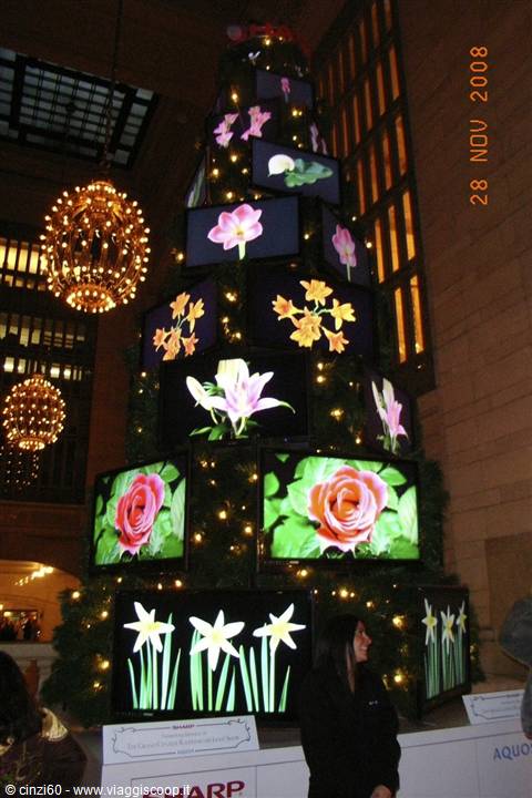 Christmas tree made of screens showing flowers, golden chandeliers, Grand Central Terminal