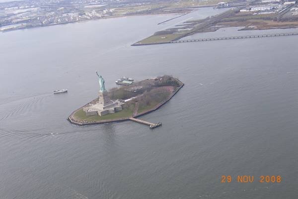 Statue of Liberty on Liberty Island seen from above, boat approaching