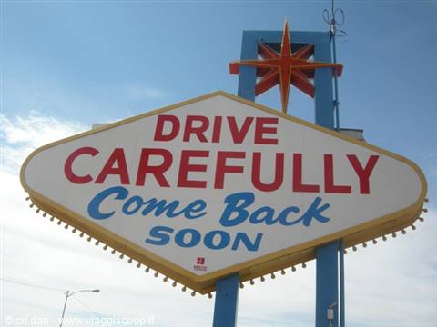 Back of the Las Vegas sign reading 'Drive Carefully, Come Back Soon' with golden star