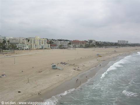 Lifeguard tower and strollers on Santa Monica sand, Pacific waves under overcast sky