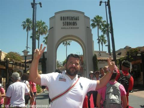 Smiling tourist flashing peace signs at the Universal Studios Hollywood entrance