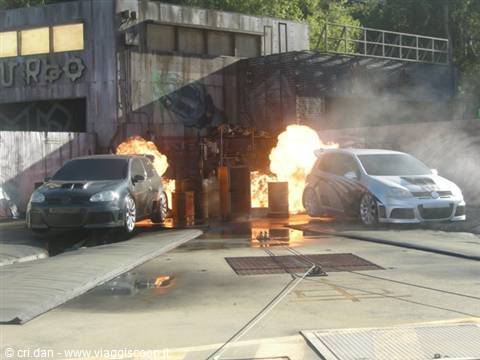 Two rally cars amid fire explosions in a stuntman show with thick smoke