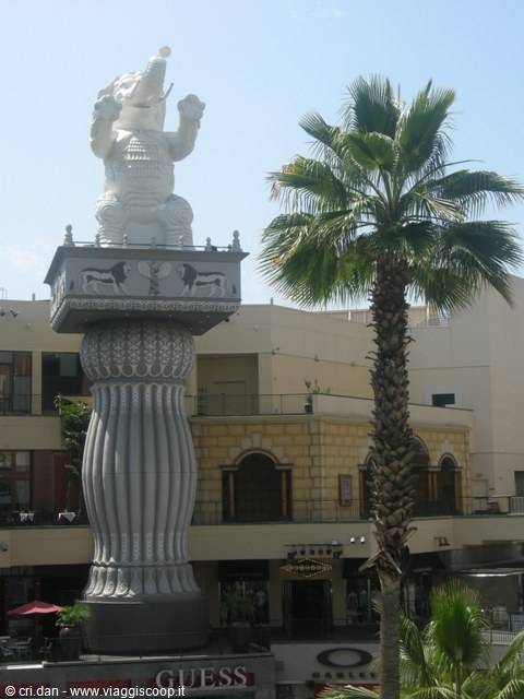 White elephant statue on Babylon column at Hollywood & Highland, next to a palm tree