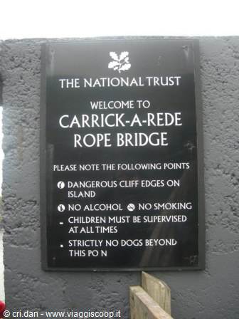 Black National Trust sign welcoming visitors to Carrick-a-Rede Rope Bridge