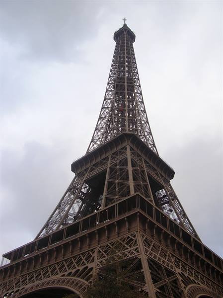 The Eiffel Tower wrought iron against a cloudy sky