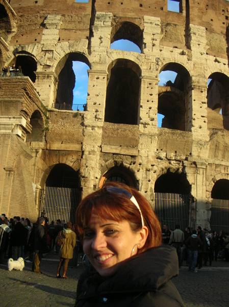 Smiling woman in front of the Colosseum arches in Rome