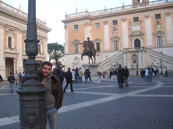 Tourist beside a lamppost in Piazza del Campidoglio, with the equestrian Marcus Aurelius statue