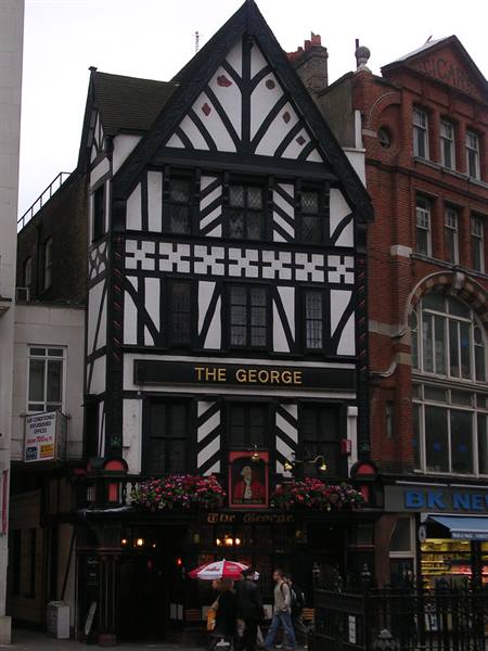 The George pub in London, black and white timber-framed facade with hanging flowers
