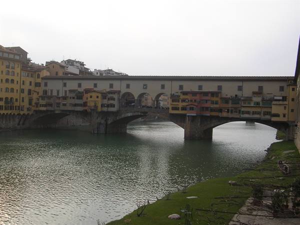 Ponte Vecchio in Florence, stone arches over the Arno under grey sky