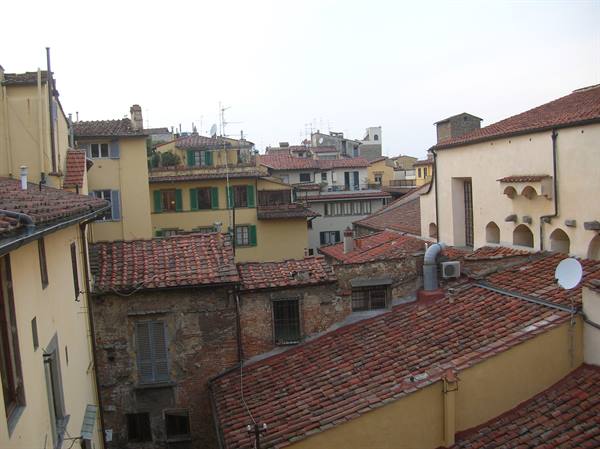 Terracotta rooftops of ochre plastered houses, grey daylight, Florence