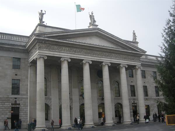 Dublin General Post Office: stone columns, rooftop statues, Irish flag flying