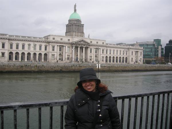 Smiling woman in front of Dublin's Custom House along the River Liffey