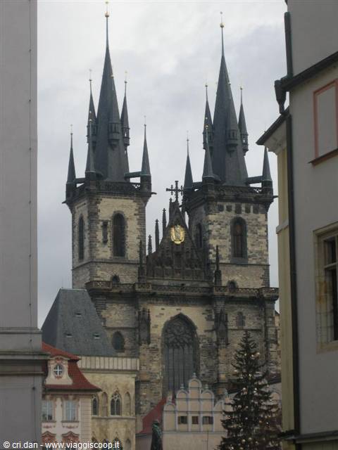 Tyn Church in Prague, dark Gothic spires framed by buildings under cloudy sky