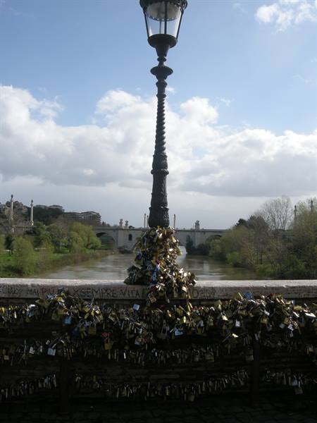 Lamppost covered in love padlocks on Ponte Milvio, Rome, with the Tiber