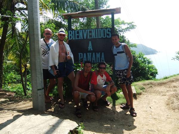 Four tourists by the Bienvenidos a Panama sign on the coastal trail