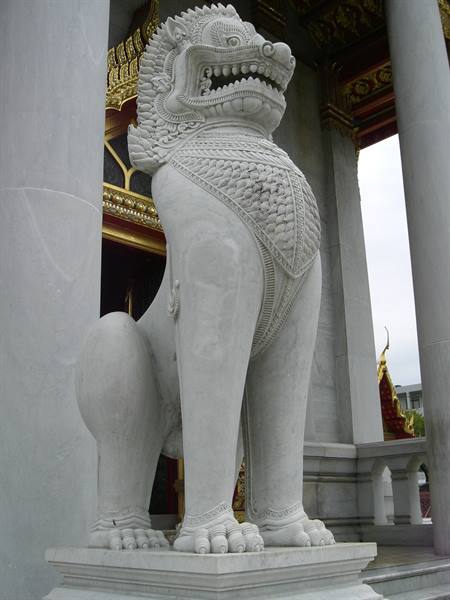 White marble guardian lion statue at the temple entrance