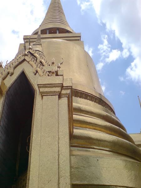 Golden stupa of Wat Phra Kaew in Bangkok against a blue sky