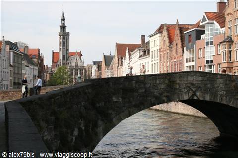Stone bridge over a canal in Bruges, stepped gables and gothic belfry