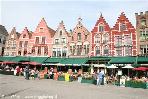 Stepped gabled houses on Bruges Markt square, cafés with green awnings and parasols
