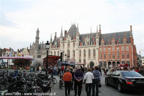 Cyclists and tourists on Bruges Markt facing the Gothic Provinciaal Hof