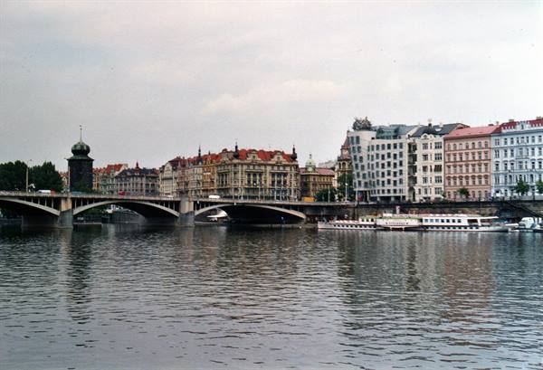 Bridge over the Vltava in Prague with historic houses and Dancing House