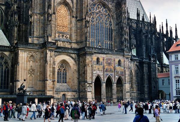Tourists in front of the Gothic stone facade of St. Vitus Cathedral, Prague