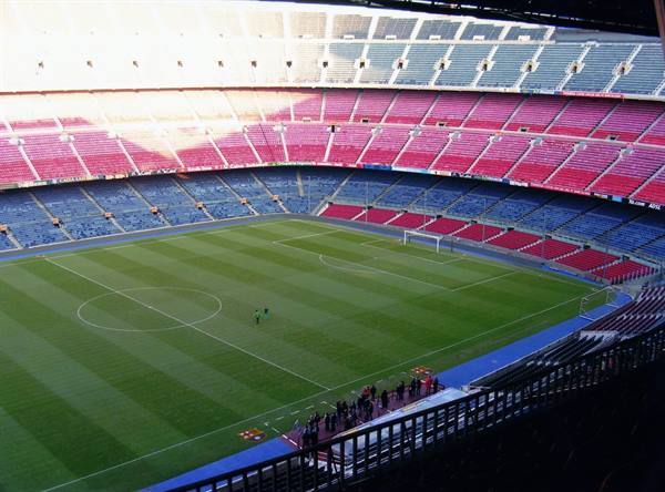 Camp Nou stadium, empty blue and red stands around the grass pitch