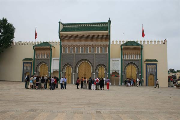 Tourists in front of the golden gates of Fès Royal Palace