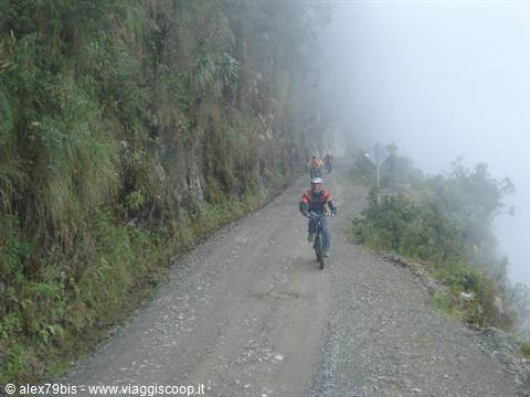 Mountain bikers on narrow foggy gravel road, Yungas