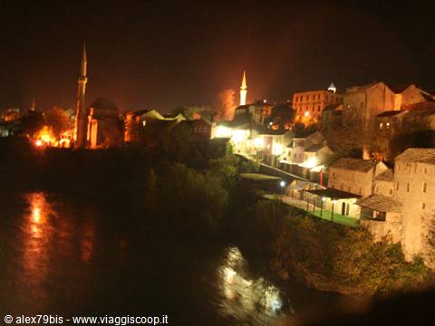 Mostar at night: illuminated minaret and old houses above the Neretva river
