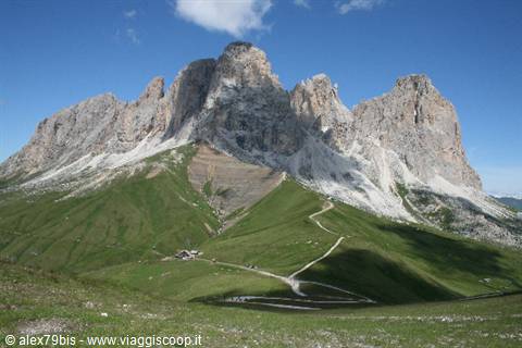 Trail winding through green meadows beneath the Dolomite peaks at Passo Gardena
